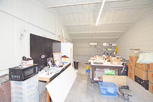 interior space with vaulted ceiling and concrete flooring