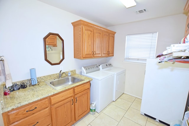 clothes washing area featuring cabinets, washing machine and clothes dryer, sink, and light tile patterned floors