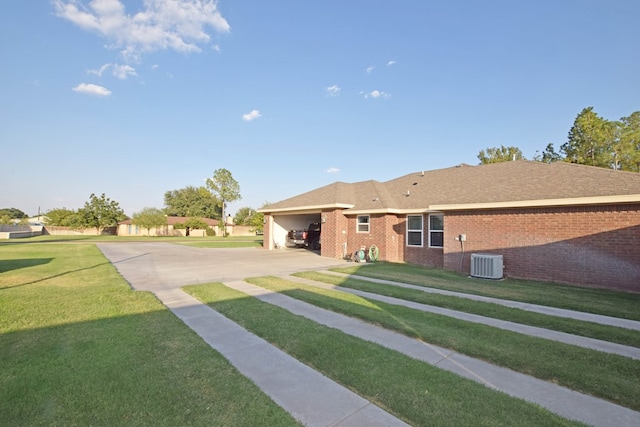 view of front of property featuring a carport, cooling unit, and a front lawn