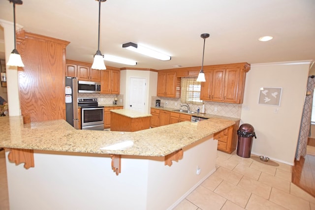 kitchen featuring appliances with stainless steel finishes, kitchen peninsula, sink, and a breakfast bar area