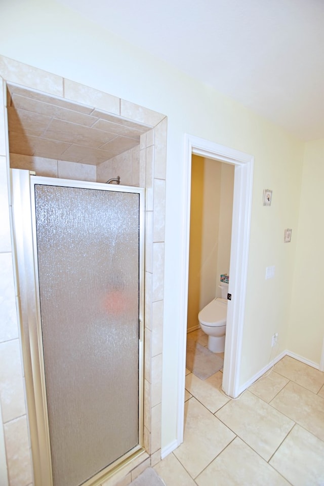 bathroom with tile patterned floors, a shower with door, and toilet