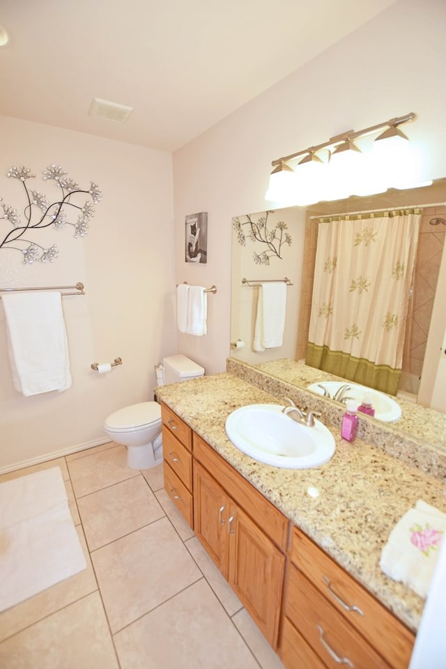 bathroom featuring vanity, tile patterned floors, toilet, and walk in shower