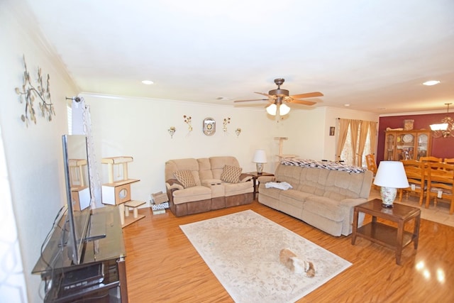 living room featuring crown molding, ceiling fan with notable chandelier, and light wood-type flooring