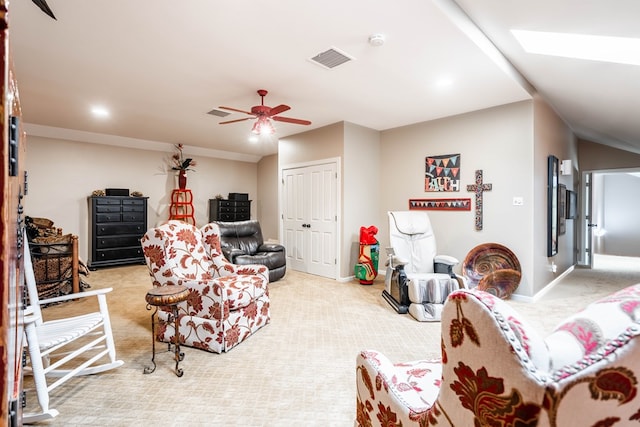 living room featuring ceiling fan, light carpet, and a skylight