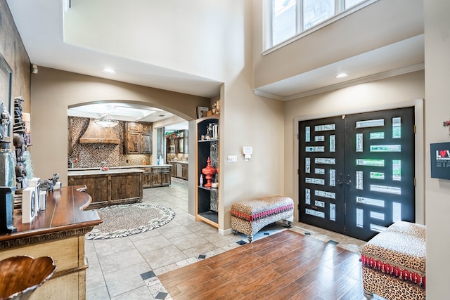 tiled foyer featuring crown molding and french doors