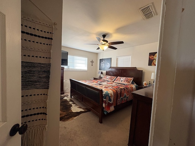 bedroom with visible vents, a ceiling fan, and carpet flooring