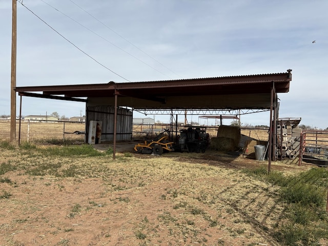 view of pole building with a carport and fence