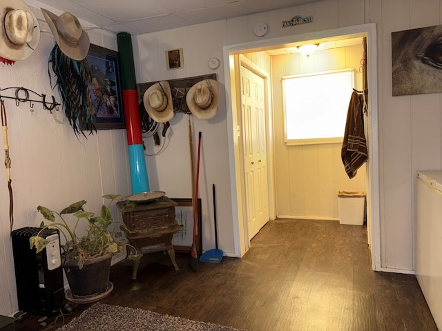 corridor featuring a paneled ceiling and wood finished floors