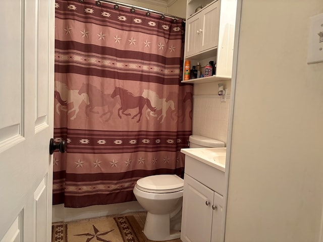 bathroom featuring toilet, vanity, and a shower with curtain