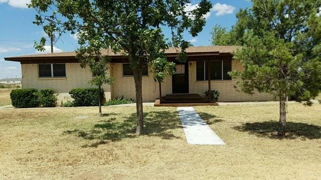 ranch-style home featuring a front lawn and brick siding