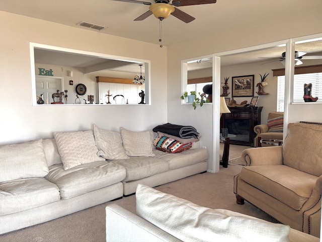 living room featuring a wealth of natural light, visible vents, carpet, and ceiling fan