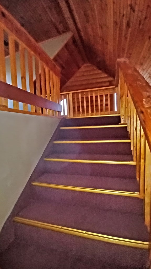 stairs with lofted ceiling and wooden ceiling