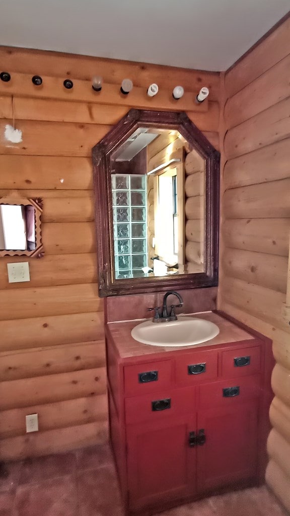 bathroom with rustic walls and vanity