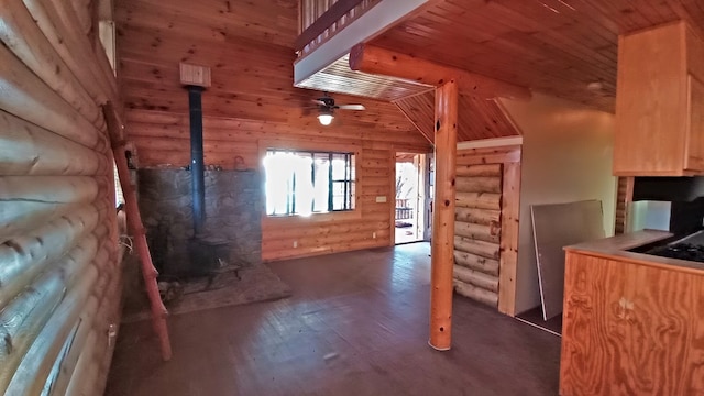 kitchen featuring vaulted ceiling with beams, dark hardwood / wood-style floors, ceiling fan, and rustic walls