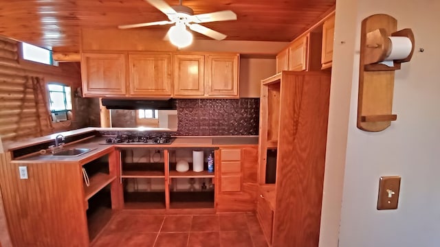 kitchen with sink, tasteful backsplash, dark tile patterned flooring, and wood ceiling