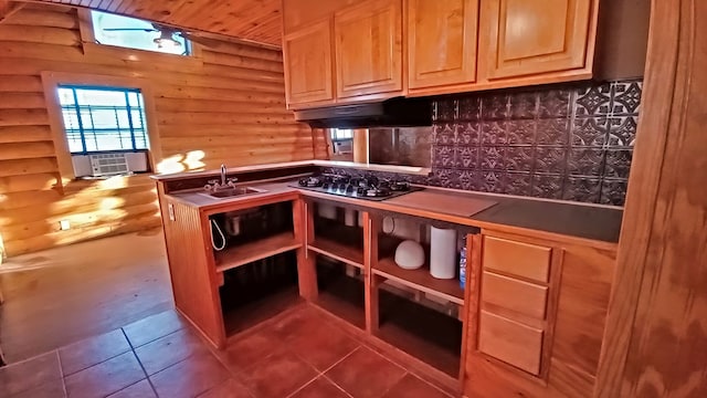 kitchen with sink, log walls, gas stovetop, backsplash, and wood ceiling