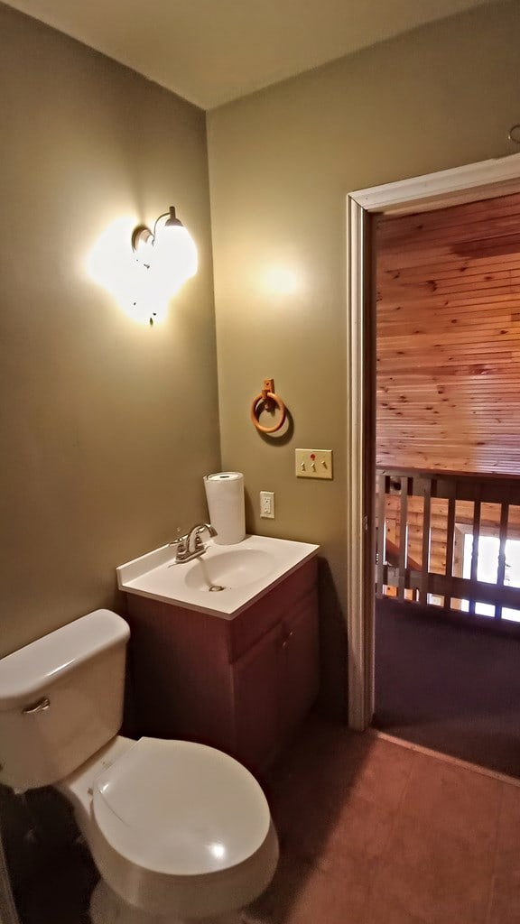 bathroom featuring tile patterned flooring, vanity, and toilet