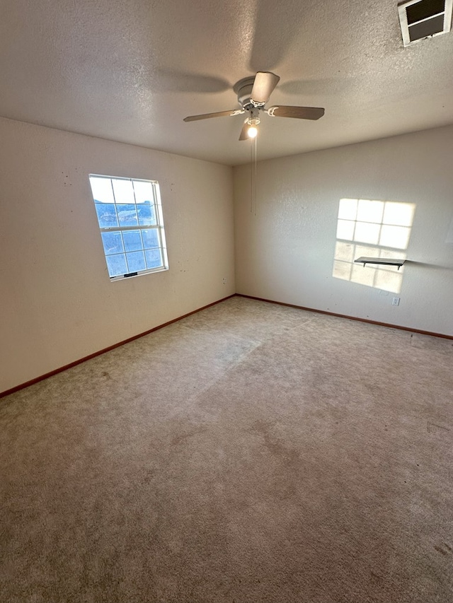 unfurnished room with ceiling fan, carpet floors, and a textured ceiling