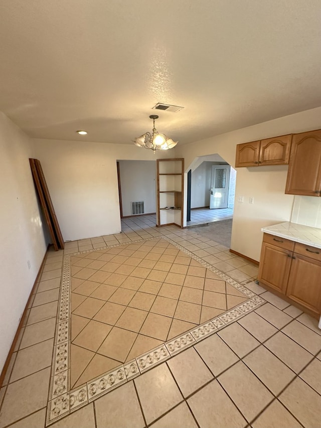 interior space with a notable chandelier and light tile patterned floors