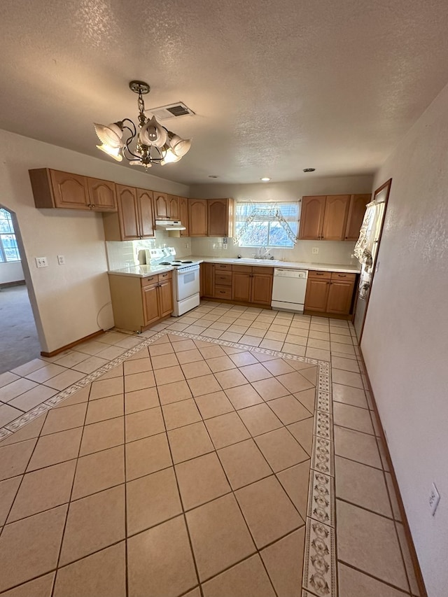 kitchen featuring white appliances, hanging light fixtures, a notable chandelier, a textured ceiling, and light tile patterned flooring