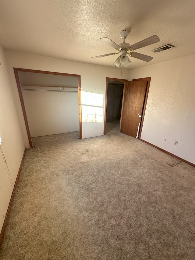 unfurnished bedroom featuring ceiling fan, a textured ceiling, and carpet flooring