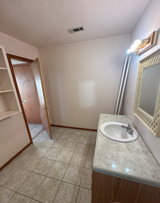 bathroom with vanity, tile patterned flooring, and a textured ceiling