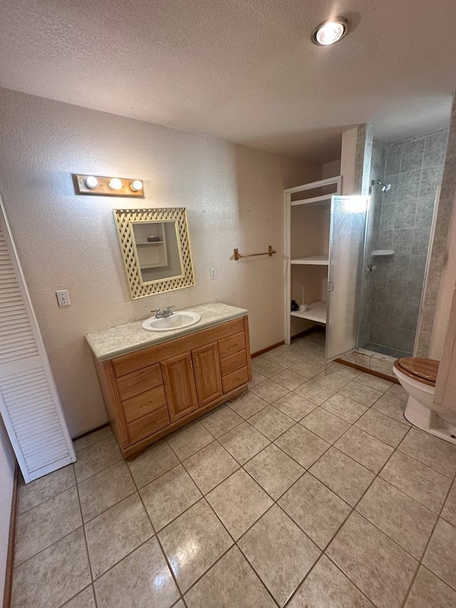 bathroom featuring vanity, an enclosed shower, toilet, tile patterned floors, and a textured ceiling