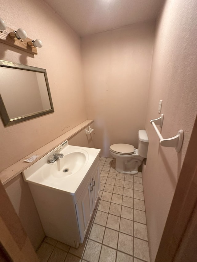 bathroom featuring tile patterned flooring, vanity, and toilet