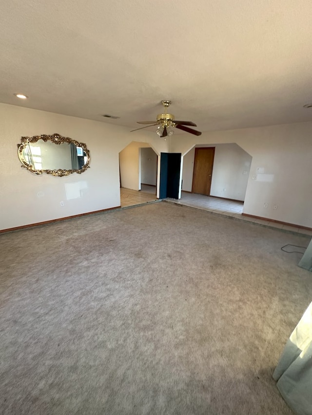 unfurnished living room with ceiling fan and carpet flooring