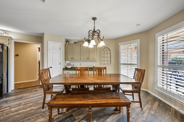 dining room with a healthy amount of sunlight, an inviting chandelier, baseboards, and dark wood-style flooring