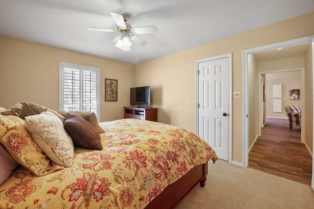 bedroom featuring light carpet, baseboards, and a ceiling fan