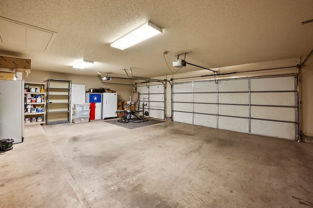 garage featuring white fridge and a garage door opener