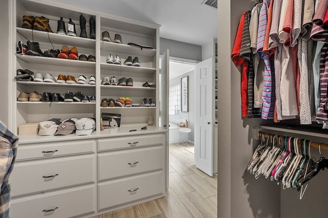 spacious closet featuring wood finish floors and visible vents