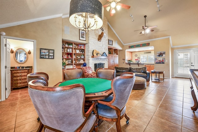 dining room featuring vaulted ceiling, a stone fireplace, and tile patterned flooring