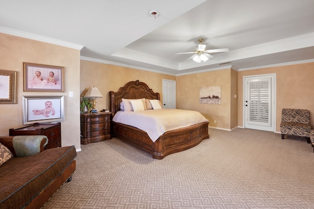 carpeted bedroom featuring crown molding, a raised ceiling, and ceiling fan