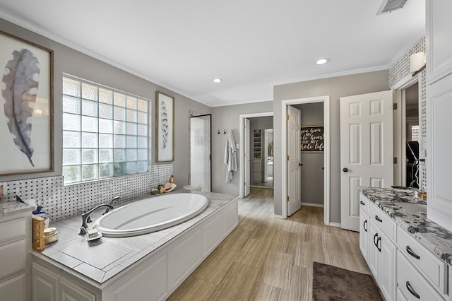 full bath with a garden tub, tasteful backsplash, visible vents, and ornamental molding