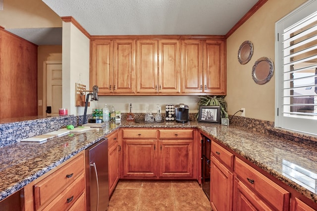 kitchen featuring a textured ceiling, ornamental molding, dark stone counters, and brown cabinets