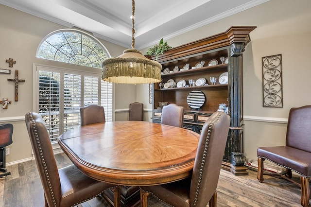 dining area featuring ornamental molding, a tray ceiling, and wood finished floors