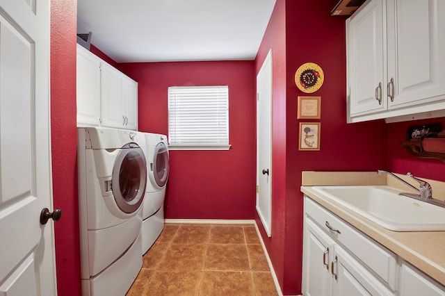 laundry room with light tile patterned floors, cabinet space, a sink, independent washer and dryer, and baseboards