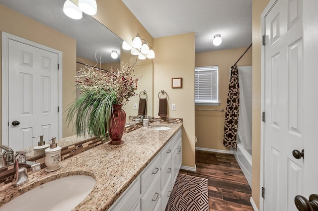 full bath featuring shower / bath combination with curtain, wood finished floors, a sink, and double vanity