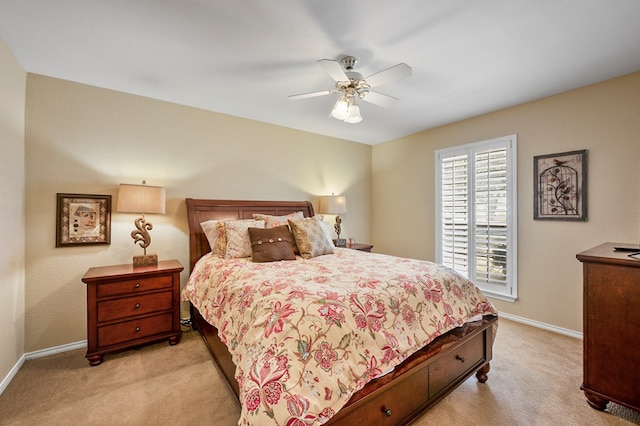 bedroom featuring a ceiling fan, light colored carpet, and baseboards