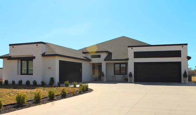 view of front facade featuring an attached garage, concrete driveway, and stucco siding