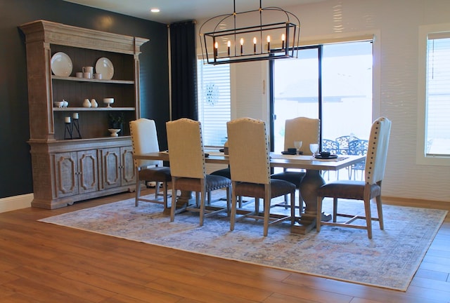 dining room with a chandelier, baseboards, and wood finished floors