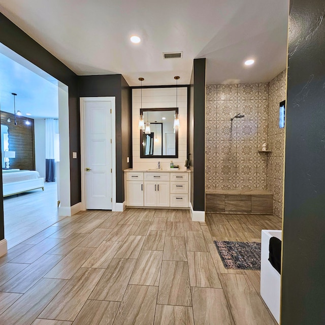 bathroom with a walk in shower, recessed lighting, vanity, visible vents, and baseboards