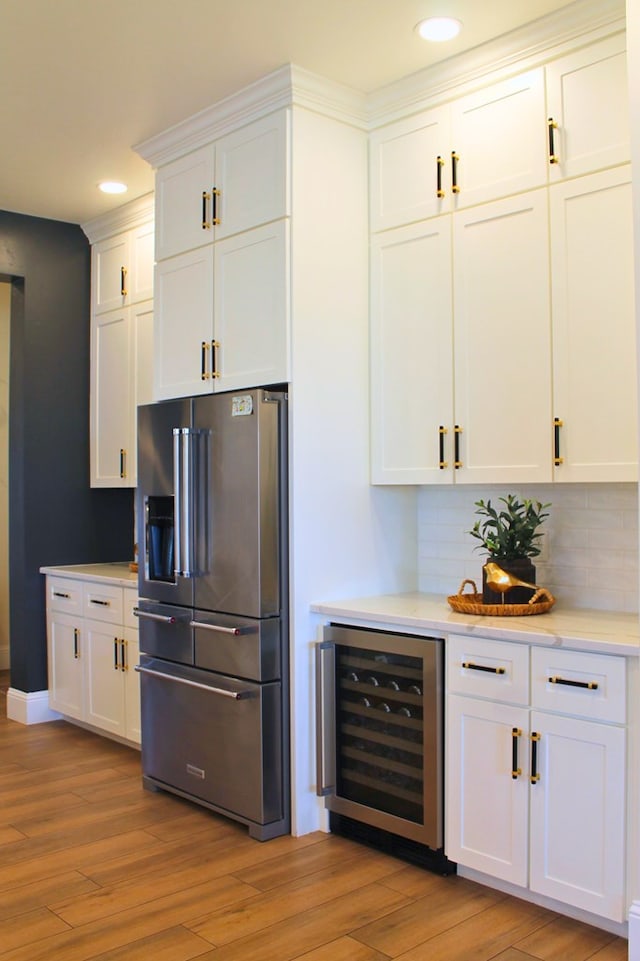 kitchen with light wood finished floors, beverage cooler, high quality fridge, and light countertops