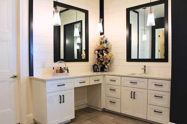 full bathroom featuring double vanity, a sink, and wood finished floors