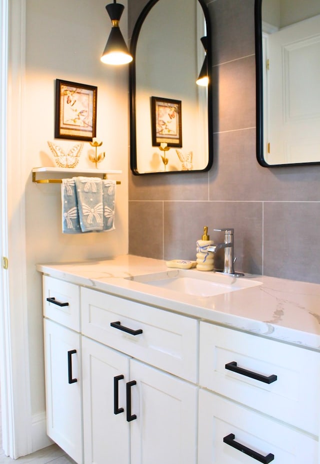 bathroom with tile walls, vanity, and decorative backsplash