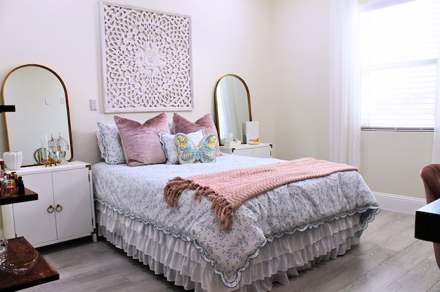 bedroom with baseboards and wood finished floors