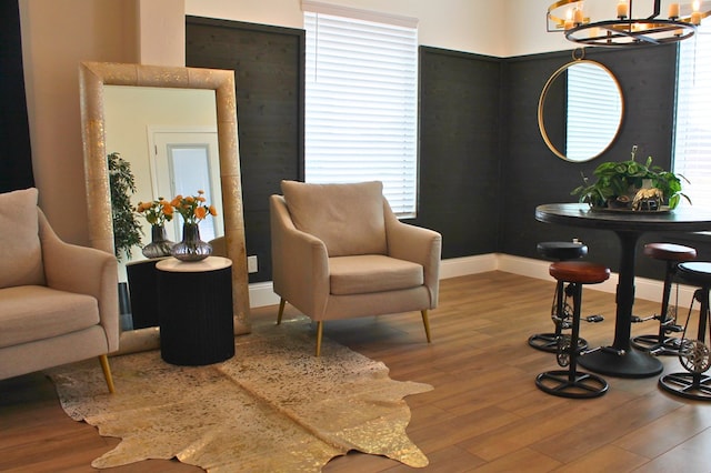 sitting room with baseboards, a chandelier, and wood finished floors