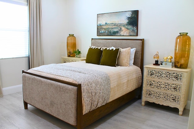 bedroom with light wood-type flooring and baseboards